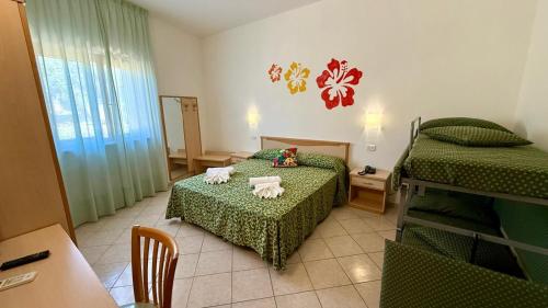 a room with two beds and a table and a table at Ibisco Hotel in Rodi Garganico