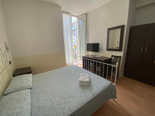 a bedroom with a bed and a desk with a mirror at Memole Inn Sanremo in Sanremo