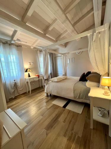 a bedroom with a bed and a wooden floor at Agriturismo Tenuta il Molino in Gabbro