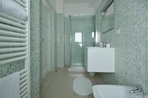 a bathroom with a white sink and green tiles at Al Quarantacinque in Maglie