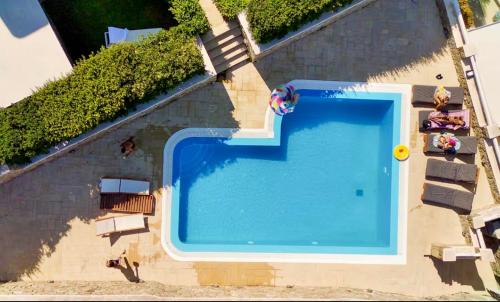 an overhead view of a swimming pool with people sitting around it at Grace Villa Mykonos in Mikonos