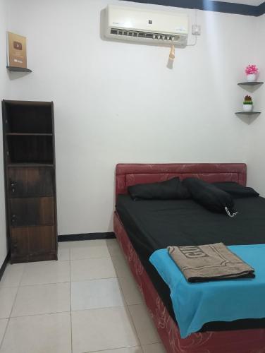 1 dormitorio con 1 cama y aire acondicionado en Zzz Motel, en Babagan