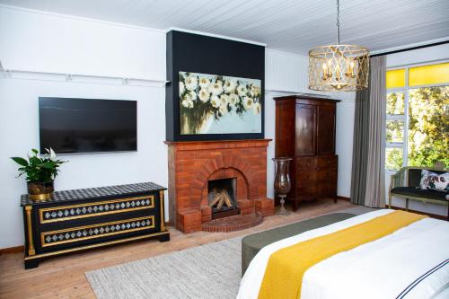 a bedroom with a fireplace and a bed and a tv at Paarl Hideaway in Paarl
