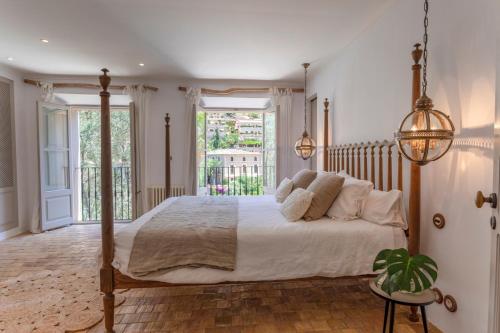 a bedroom with a large bed and a balcony at Mallorca Villa with Private Pool, Villa 1009 in Deia