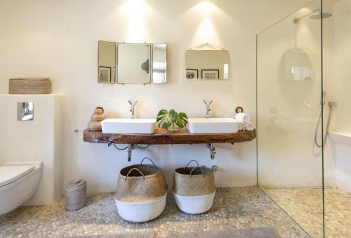 a bathroom with two sinks and two mirrors at Mallorca Villa with Private Pool, Villa 1009 in Deia