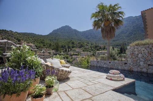 a patio with a palm tree and a swimming pool at Mallorca Villa with Private Pool, Villa 1009 in Deia