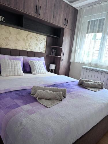a bedroom with a large bed with two pillows on it at Primavera apartments Banja Koviljaca in Banja Koviljača