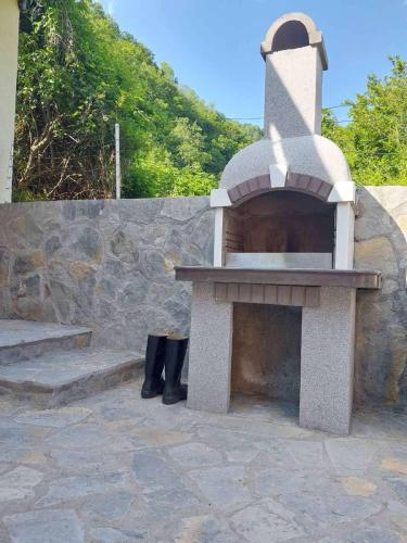 a stone oven sitting next to a stone wall at KoCHALET Apartment in Crni Vrh