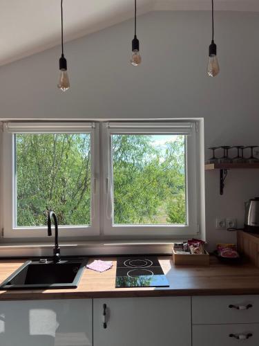 a kitchen with two windows and a kitchen sink at Stan Maric in Široki Brijeg