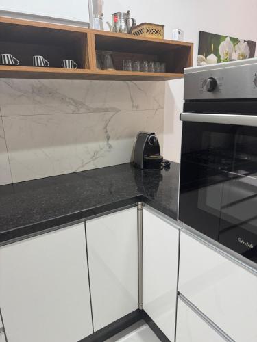 a kitchen with white cabinets and a black and white stove at Iquama atawhid I in Nador