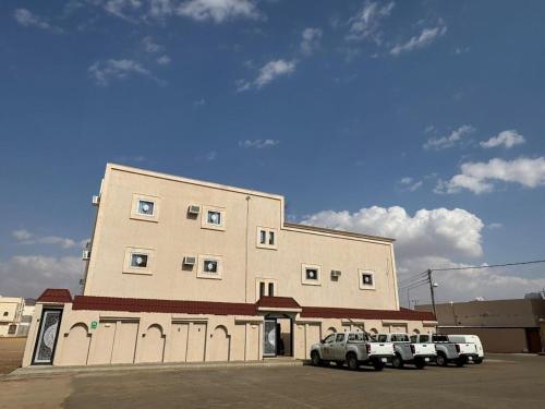 a building with three cars parked in front of it at شقق الزهور - العزيزية in AlUla