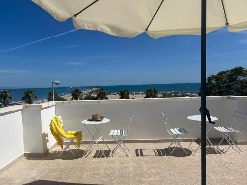 a balcony with a table and chairs and the beach at Casa vacanze SoleeMare Barletta Apartments in Barletta