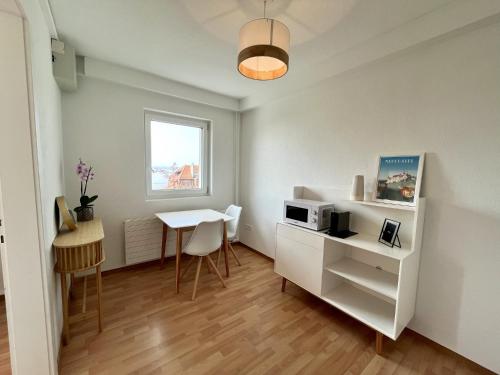 a small room with a table and a microwave at HostHelp - Le Petit-Catéchisme in Neuchâtel
