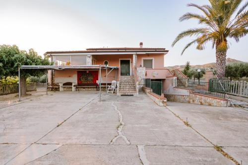 una casa con una palmera y un camino de entrada en Villa Don Pè, en Roccella Ionica