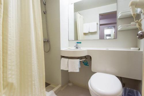 a bathroom with a toilet and a sink and a mirror at Bestay Hotel Express Shenyang Imperial Palace Huaiyuanmen Subway Station in Shenyang
