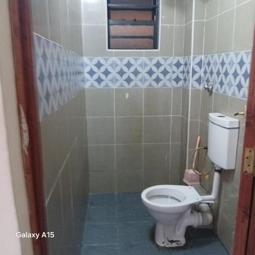 a small bathroom with a toilet and a window at Dhahabu homes in Kitengela 