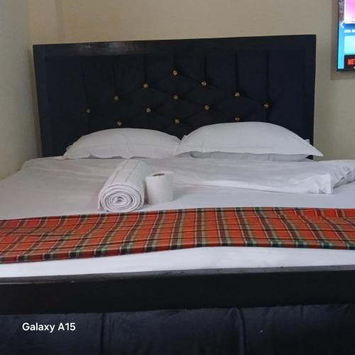 a bed with a blanket and a candle on it at Dhahabu homes in Kitengela 