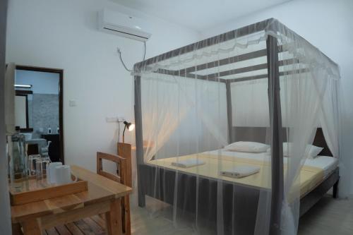 a bedroom with a canopy bed with a wooden table at Wild Edge Panama - Kumana Safari Lodge in Panama