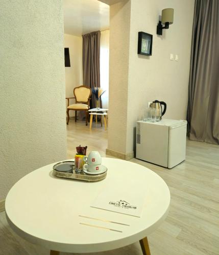 a white table with a plate on top of it at Hotel Saint Nedelya in Kolarovo