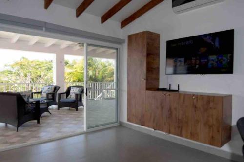 a living room with a flat screen tv on the wall at Villa Agueda Decameron, golf club and swimming pool in Río Hato