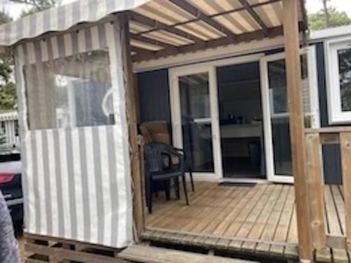 a wooden deck with a pergola on a house at Bonne Anse plage 411 mobile home 3 chambres in Les Mathes