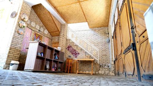 a large room with a building with a wooden door at Old Street Guesthouse in Bukhara
