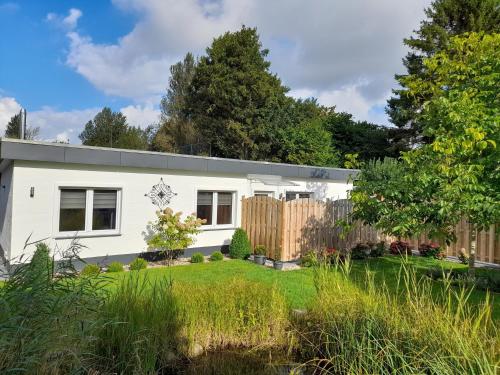 a white house with a fence in a yard at Ferienhaus Stamer in Eckernförde