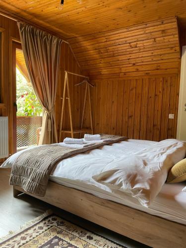 Una cama grande en una habitación con techo de madera. en Cabana Mistic, en Bran