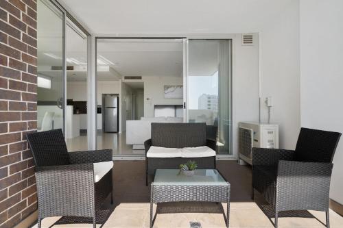 a patio with two chairs and a table and a bedroom at 81M City View Abnb-Style 3BR Near Mascot Station with 2 FPKG in Sydney
