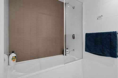 a bathroom with a shower and a sink with a mirror at 81M City View Abnb-Style 3BR Near Mascot Station with 2 FPKG in Sydney