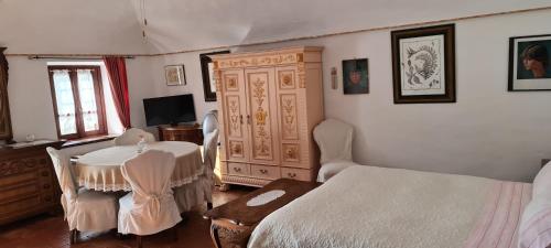 a bedroom with a bed and a table and a dresser at L'Oasi Bed and Breakfast di Franco e Paola in San Martino Canavese