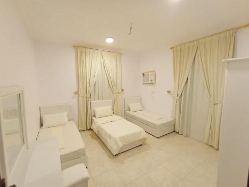 a white room with a bed and a couch at شقق الزهور - العزيزية in AlUla