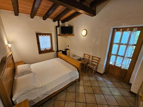 a bedroom with a bed and a table and chairs at Agriturismo L'Urteia in Pieve Dugliara