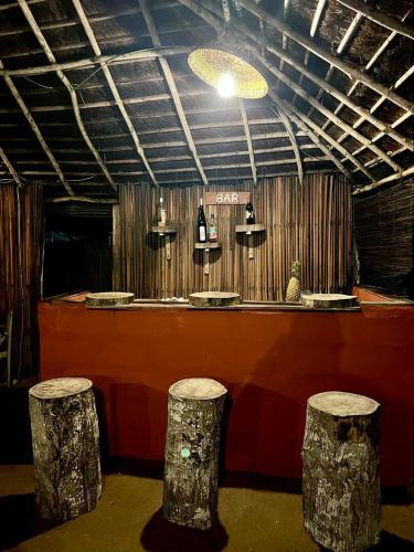 a bar with two stools in front of a counter at Village Kirikou in Grand-Popo