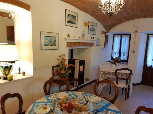 a dining room with a table and chairs and a fireplace at L'Oasi Bed and Breakfast di Franco e Paola in San Martino Canavese