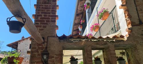 an old building with potted plants and a blue sky at L'Oasi Bed and Breakfast di Franco e Paola in San Martino Canavese