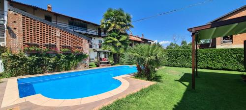 a swimming pool in the yard of a house at L'Oasi Bed and Breakfast di Franco e Paola in San Martino Canavese