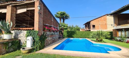 a swimming pool in a yard next to a house at L'Oasi Bed and Breakfast di Franco e Paola in San Martino Canavese