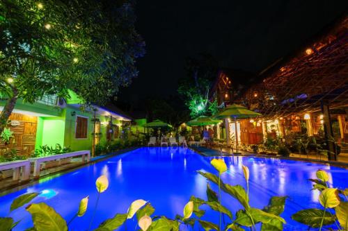 a large blue swimming pool at night at Bamboo Hotel Phu Quoc in Phu Quoc