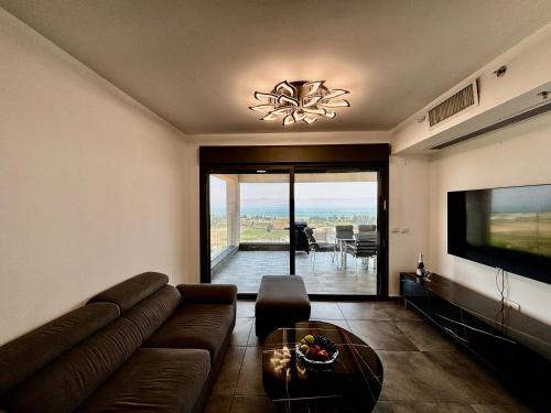 a living room with a couch and a flat screen tv at Yalarent C Kinneret Amazing Apartments in Migdal