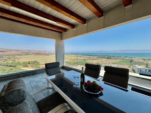 a dining room with a table and chairs and a large window at Yalarent C Kinneret Amazing Apartments in Migdal