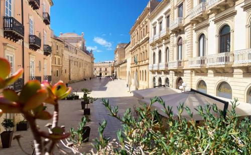 an empty city street with buildings and an umbrella at Il Salotto di Maria Pia in Siracusa
