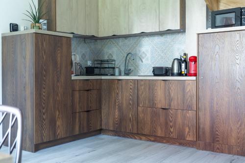 a kitchen with wooden cabinets and a counter top at Na Górce 13 in Polańczyk