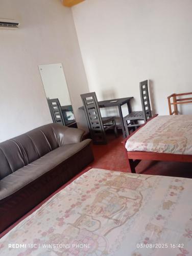 a living room with a couch and a table and chairs at Our Little Secret in Kalutara