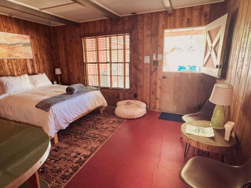a bedroom with a bed and a chair and a window at Room 2 - Downtown Joshua Tree Motel - Pet Friendly - Walk to Shops & Visitor Center, Minutes to Park Entrance in Joshua Tree