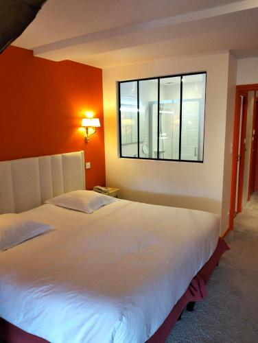 a bedroom with a large bed and a window at Les Saules Parc & Spa - Teritoria in Vonnas