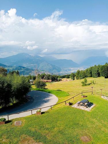 a view of a field with a river and mountains at Appartamento Lulù Polsa in Brentonico