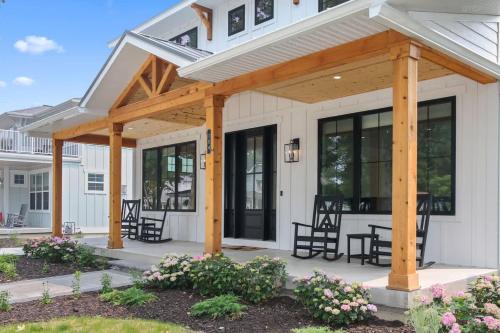 a pergola on a white house with black windows at expERIEnce in South Haven