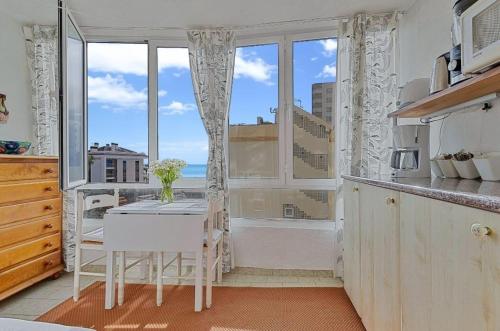 a kitchen with a table and a large window at Apartamento Bougainvillea in Fuengirola