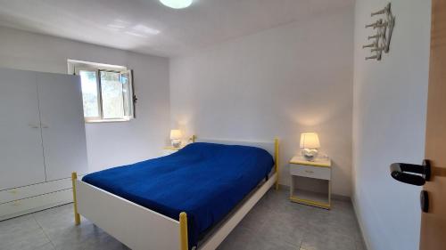 a bedroom with a blue bed and a window at Residence Family House in Vieste